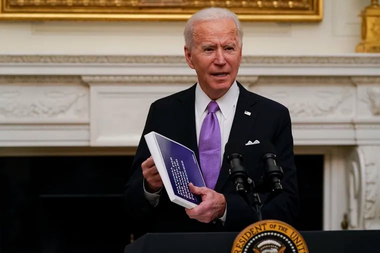 President Joe Biden holds a booklet as he speaks about the coronavirus in the State Dinning Room of the White House, Thursday, Jan. 21, 2021, in Washington.