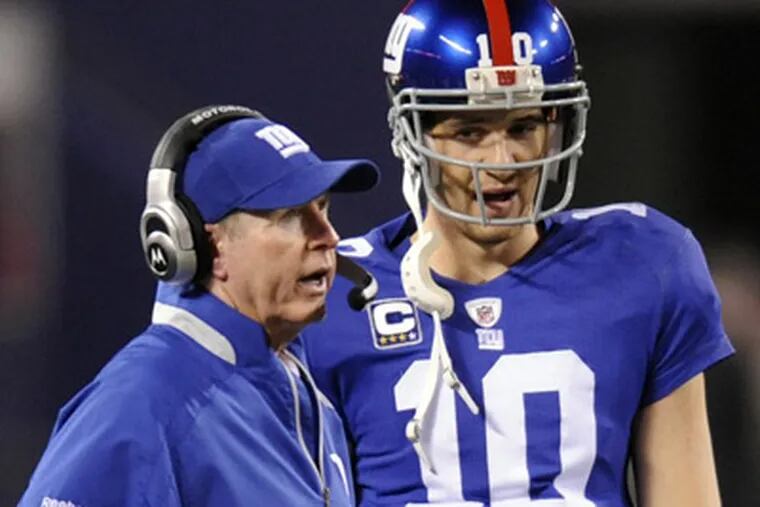 New York Giants head coach Tom Coughlin, left, talks with quarterback Eli Manning. (AP Photo)