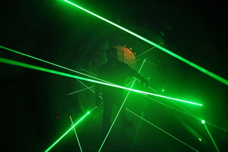 Frank Cerio, director of operations at 5 Wits, walks through lasers in a maze. The high-adventure concept debuted at Plymouth Meeting Mall on Thursday, Oct. 19.