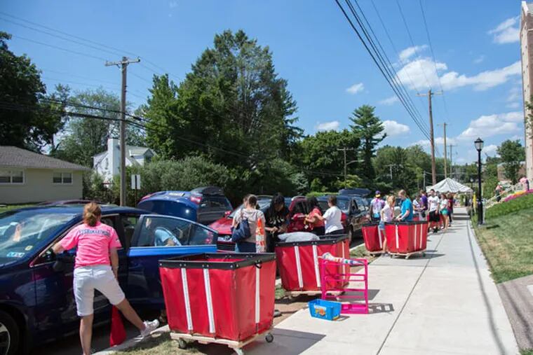 “We let [parents] know: Just chill in your car. We got everything,” a resident assistant at West Chester University said. About 600 upperclassmen volunteered to help smooth first-year students’ move-in day by directing traffic, unloading cars, and pushing carts. (EMILY COHEN/For The Inquirer)