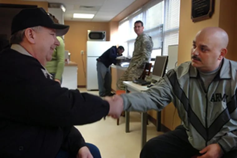 Wounded in Iraq, Army Sgt. Angel Rivera (right) greets Michael Engi of the Vietnam Veterans of America at Fort Dix, where Rivera is recovering. The new facility will centralize medical services.