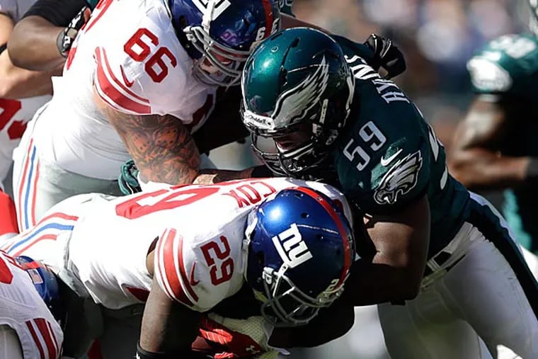Eagles linebacker DeMeco Ryans tackles Giants running back Michael Cox during the first half. (Matt Rourke/AP)
