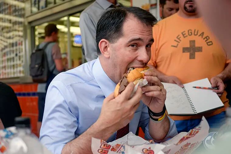 Wisconsin Gov. Scott Walker eats a meal with customers at Geno's Steaks in South Philadelphia on July 28, 2015. ( BEN MIKESELL / Staff Photographer )