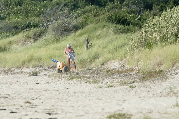 A man puts a shirt on before leaving Higbee Beach in West Cape May, NJ on Aug. 15, 2018. ELIZABETH ROBERTSON / Staff Photographer