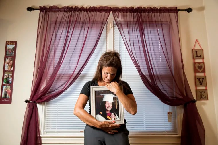Joanne DeGuio holds a photo of her daughter, Amanda DeGuio, who has been missing for five years. The photo is from her senior year at Haverford High School.