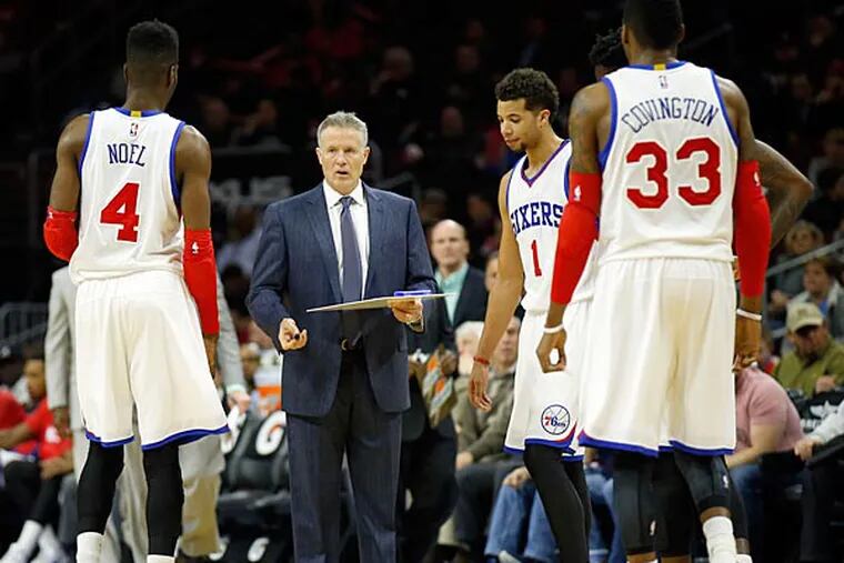 Brett Brown meets with his team during a timeout. (Yong Kim/Staff Photographer)