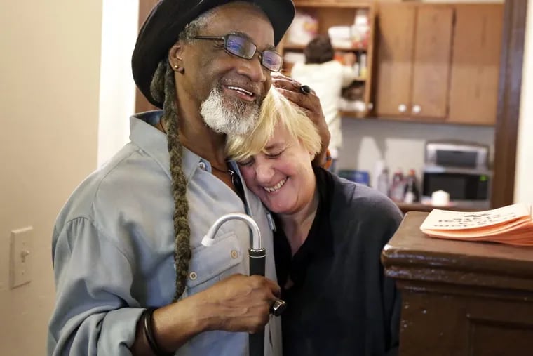 William Goldsby, chairman and founder of Reconstruction Inc. hugs Dutch artist Jeanne van Heeswijk after a community-based “Welcome Meal” for those participating in the Nicetown/Tioga “Reconstructions” art project. ( PHOTOS BY ELIZABETH ROBERTSON / Staff Photographer )