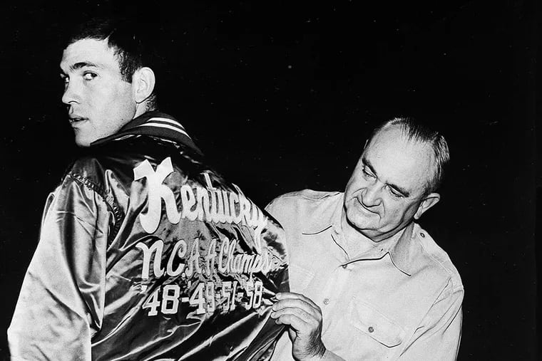 University of Kentucky coach, Adolph Rupp, looks at the back of Johnny Cox's jacket on Dec. 1, 1958.  (AP Photo)