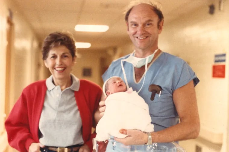 Dr. Isaacson smiles with his wife, June, after delivering their granddaughter, Zoe, in 1986.