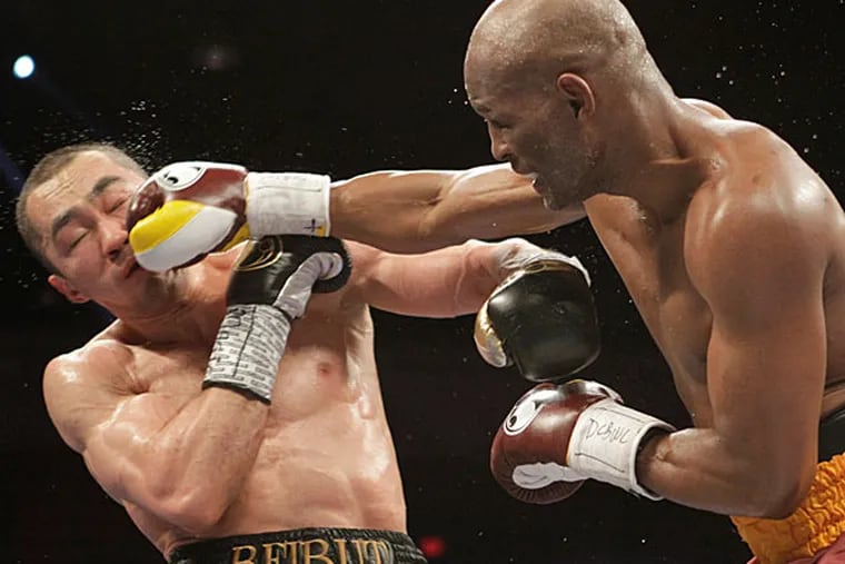Beibut Shumenov, left, of Kazakhstan, takes a punch from Bernard Hopkins, right, of the United States, during their IBF, WBA and IBA Light Heavyweight World Championship unification boxing match, Saturday, April 19, 2014, in Washington. Hopkins won by a split decision. (Luis M. Alvarez/AP)