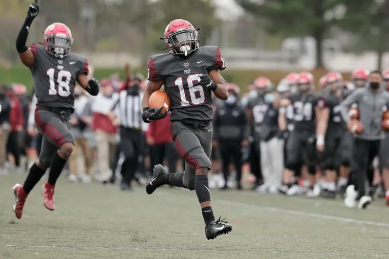 Accompanied by teammate Zavier Atkins (left), St. Joseph's Prep Malik Cooper returns the opening kick of the second half for a touchdown against Souderton on Saturday.