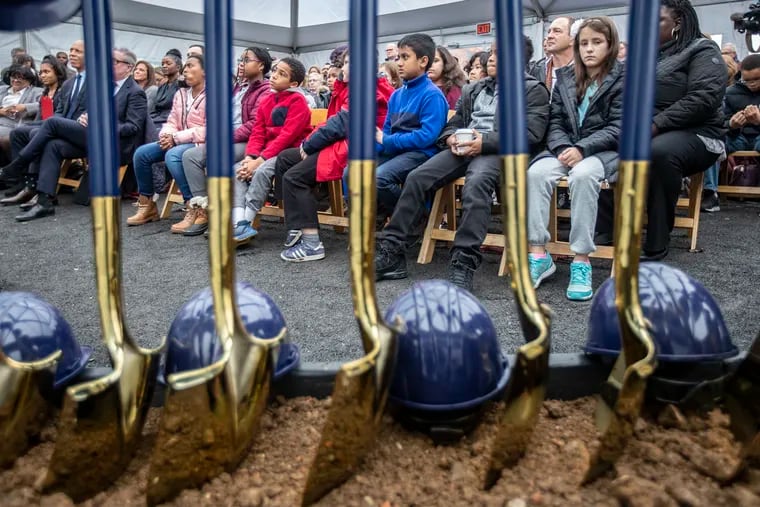 Students from Samuel Powel Elementary look over the gold-plated shovels used by dignitaries to break ground on a building in University City that will house their new school and Science Leadership Academy Middle School. The $40 million building came together with public and private money in a deal brokered by Drexel University. The building will sit on the former site of University City High School.