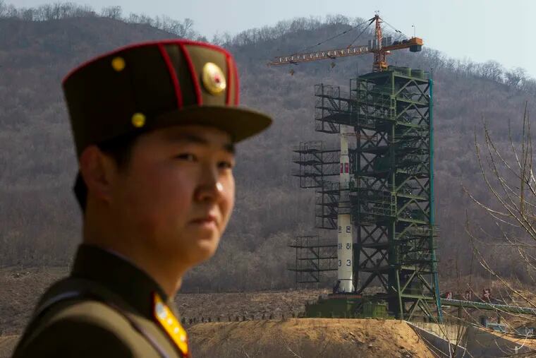 In this April 8, 2012, file photo, a soldier stands in front of the Unha-3 rocket at a launching site in Tongchang-ri, North Korea. North Korea is reportedly restoring facilities at its long-range rocket launch site that it had dismantled as part of disarmament steps last year. A major South Korean newspaper reports that the country's spy service gave such an assessment to lawmakers in a private briefing on Tuesday.
