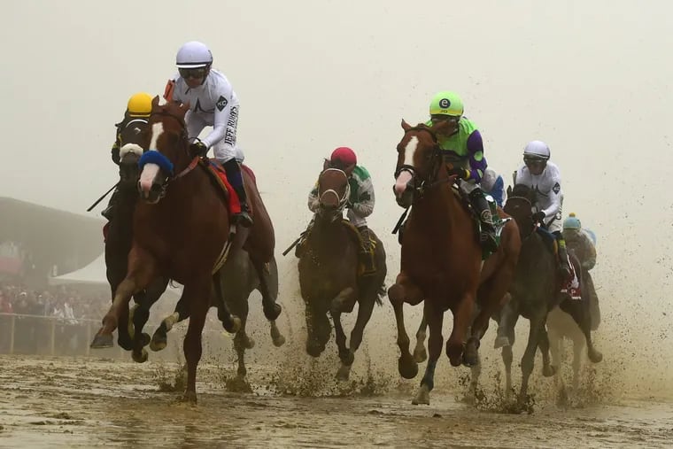 Justify, ridden by Mike E. Smith, wins the 143rd Preakness Stakes in the mud and fog to capture the second leg of the Triple Crown.