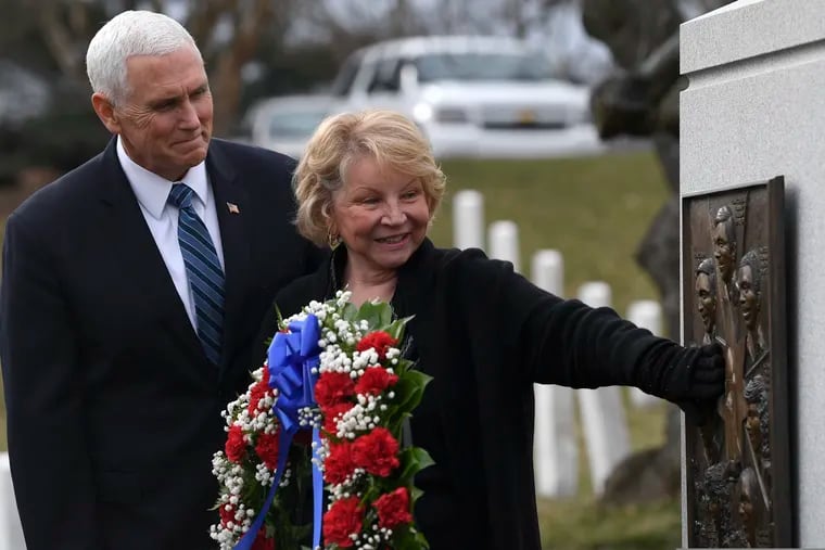 Vice President Mike Pence watches as June Scobee-Rodgers, widow of Challenger commander Dick Scobee, touches the Challenger memorial during the NASA Day of Remembrance ceremony at Arlington National Cemetery in Arlington, Va., Thursday, Feb. 7, 2019.