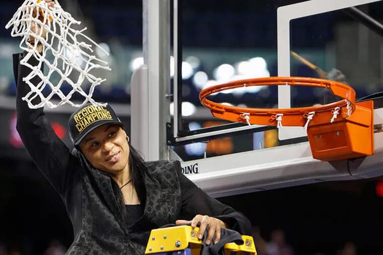 Coach Dawn Staley waves the net after South Carolina beat Florida State to make the women's Final Four. (LYNN HEY / News & Record)