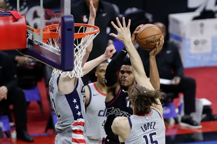 Sixers forward Tobias Harris drives to the basket against Washington Wizards center Robin Lopez and forward Davis Bertans during the first quarter in game one of the Eastern Conference quarterfinals NBA playoffs on Sunday, May 23, 2021.