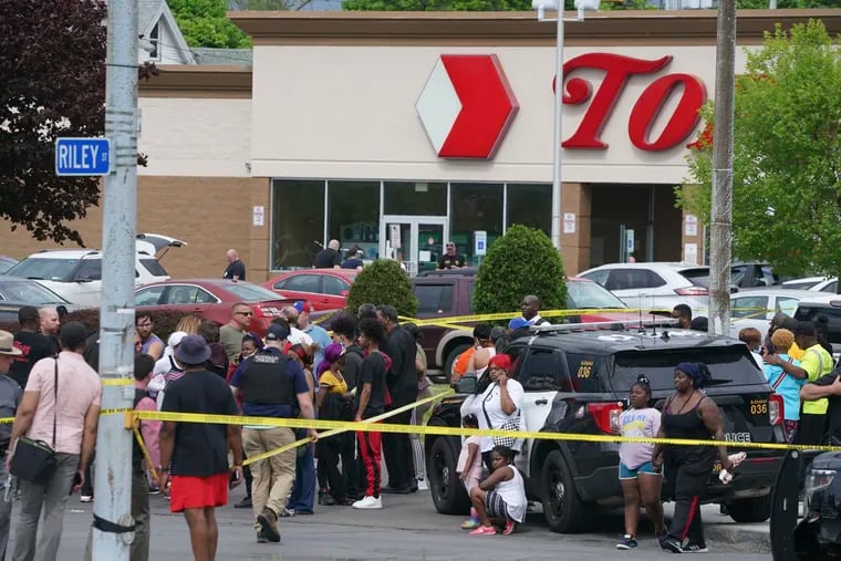 People gathering outside a supermarket where 10 people were killed in a shooting, May 14, 2022 in Buffalo, N.Y. Officials said the gunman entered the supermarket with a rifle and opened fire.