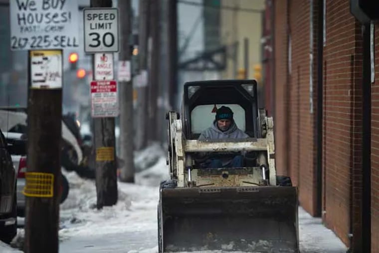 Haki Mana of Kerrs Building Materials Inc. uses a bulldozer to clear sidewalks covered with sleet and ice in Philadelphia on Monday, March 2, 2015. (Alejandro A. Alvarez / staff)