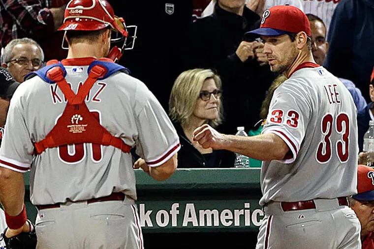 Phillies starting pitcher Cliff Lee fist-bumps catcher Erik Kratz as they go into the dugout after the eighth inning. (Elise Amendola/AP)