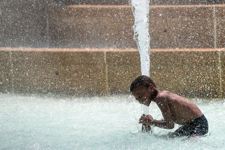 Ali-Naeem Abdus Sama plays in the Swann Memorial Fountain in Logan Square in Philadelphia on Tuesday, July 30, 2019. Despite the rule of no swimming, the fountain is a popular spot on hot summer days.