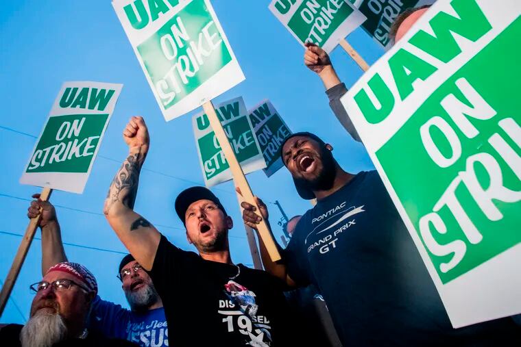 General Motors employees Bobby Caughel, left, and Flint resident James Crump, shout out as they protest with other GM employees, United Auto Workers members and labor supporters outside of the Flint Assembly Plant on Monday, Sept. 16, 2019 in Flint, Mich.