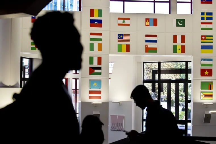Students walk through Temple's student center, where flags are displayed to represent the home countries of members of Temple's student body.