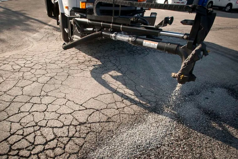 The boom on a Pothole Killer forces patching material into a pothole in the Juniata Park section of the city.
