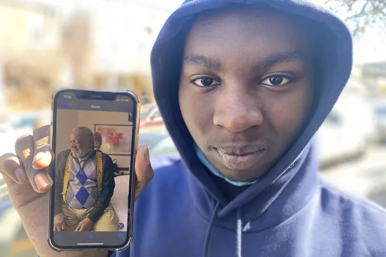 Tymire Alston-Haywood, 15, holds a cellphone picture of his great grandfather, James Watson, 69, who was killed in a ATM robbery on Thursday night.