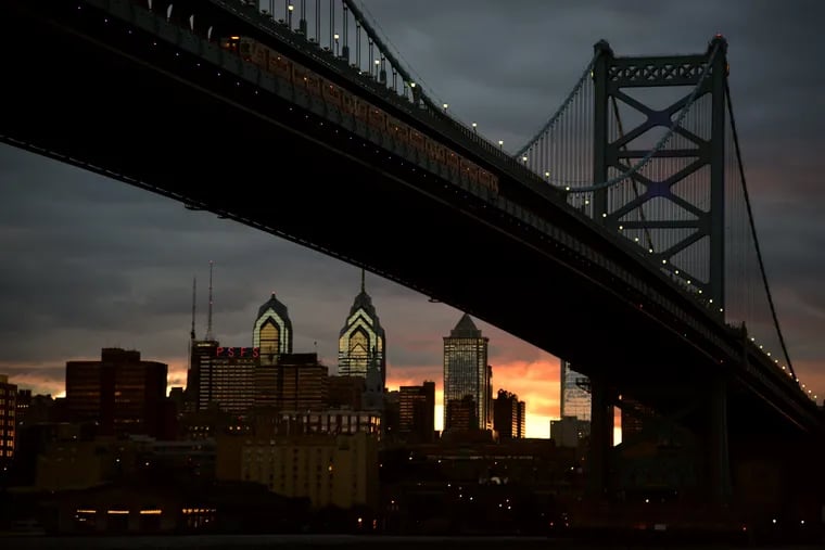 The sun sets over the Philadelphia Skyline seen behind the Benjamin Franklin Bridge from Cooper's Poynt Waterfront Park in North Camden.