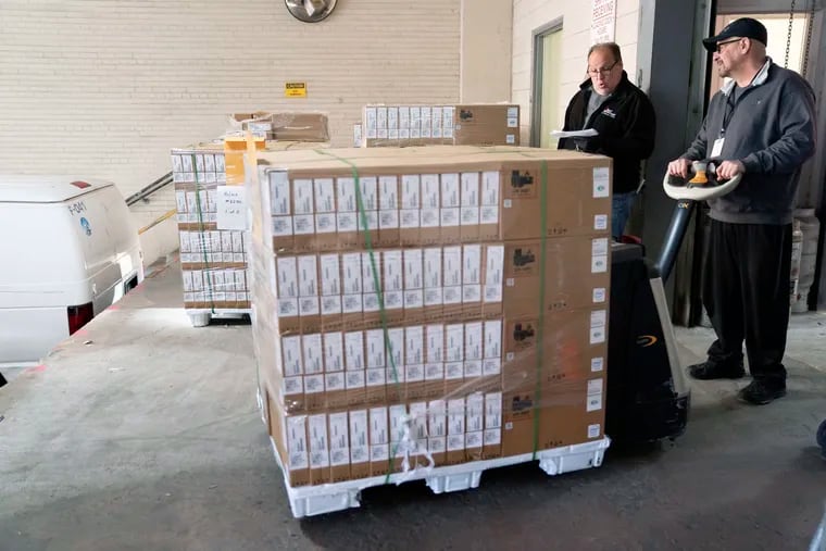 Frank Bell and Anthony Casalena ready laptops to be loaded onto trucks for delivery to city schools in April 2020. The School District provided computers to students when it pivoted to virtual instruction last year.