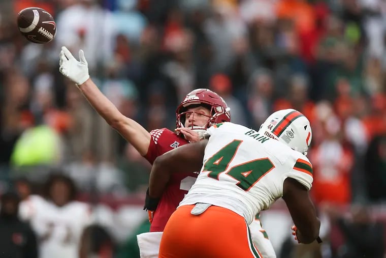 Temple quarterback E.J. Warner throws for a touchdown despite pressure from Miami defensive lineman Rueben Bain Jr. in the second quarter.