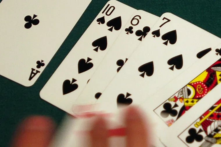 A dealer flips a poker hand.