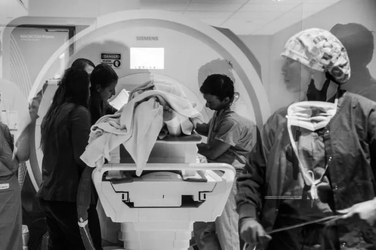Health workers and researchers remove a patient from an MRI machine at West Virginia University’s Rockefeller Neuroscience Institute April 9 during a study using ultrasound to treat addiction. MUST CREDIT: Rosem Morton for The Washington Post