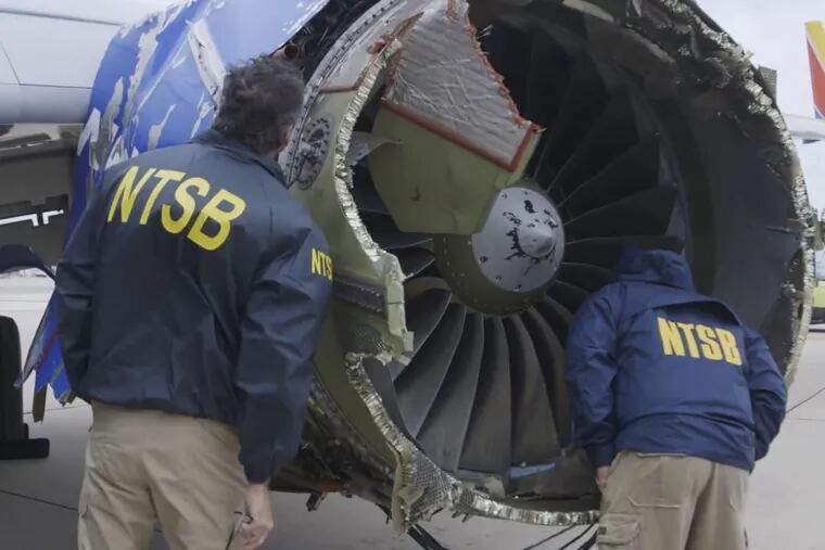 In this Tuesday, April 17, 2018, frame from video, National Transportation Safety Board investigators examine damage to the engine of the Southwest Airlines plane that made an emergency landing at Philadelphia International Airport.