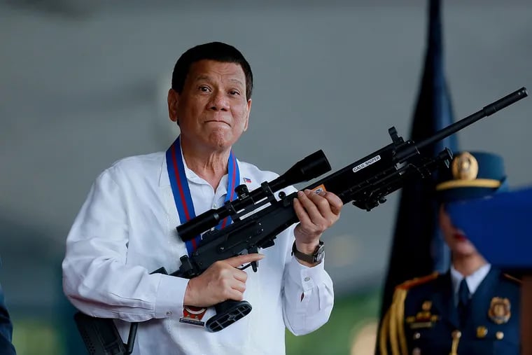 Philippine President Rodrigo Duterte holds a sniper rifle during a Philippine National Police ceremony in Quezon City, the Philippines, in April 2018.
