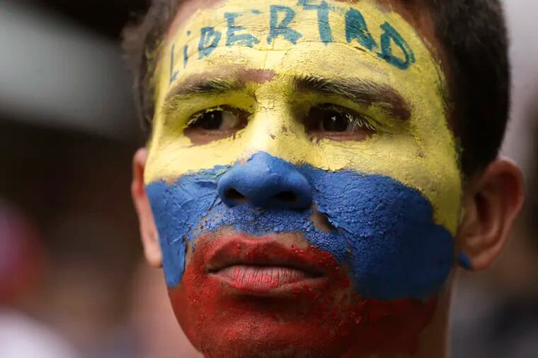 An opponent to Venezuela's President Nicolas Maduro, his face the colors of the Venezuelan national flag and the Spanish word for "Freedom" written on his forehead, takes part in a march in Caracas, Venezuela, Saturday, May 4, 2019. Opposition leader Juan Guaido took his quest to win over Venezuela's troops back to the streets, calling his supporters to participate in an outreach to soldiers outside military installations across the country.