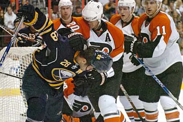 Flyers defenseman Chris Pronger takes a swipe at Buffalo Sabres Paul Gaustad's head, knocking his helmet off, during a first period scrum in front of the Flyers goal.  Both players were given 2-minute roughing penalties. (Clem Murray / Staff Photographer)