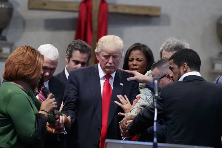 People lay hands on then-Republican presidential candidate Donald Trump as they pray during a pastors leadership conference in Cleveland, Ohio, in September of 2016.