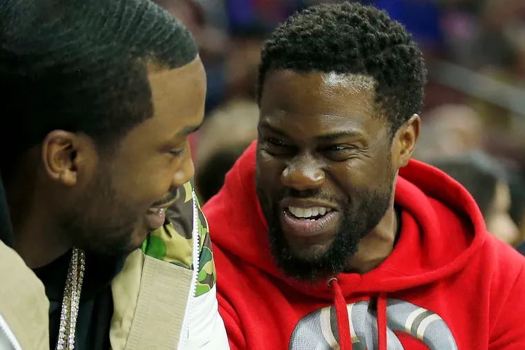 Comedian Kevin Hart looks over at hip hop artist Meek Mill while the Sixers played the Rockets.  YONG KIM/Staff Photographer