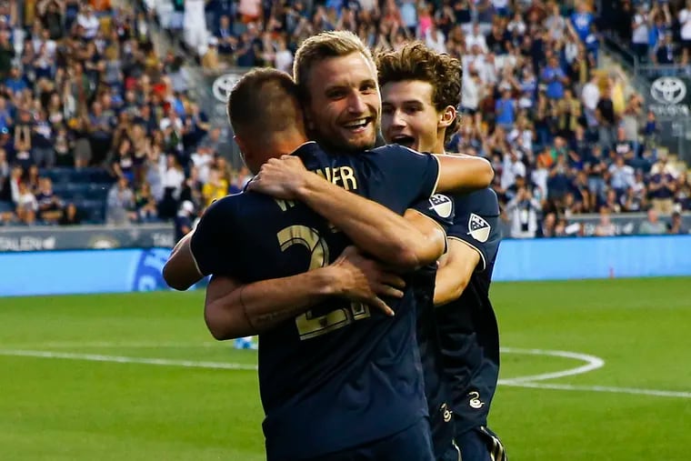 Union forward Kacper Przybylko (center) celebrates his first half goal against D.C. United with teammates Kai Wagner and Brenden Aaronson.