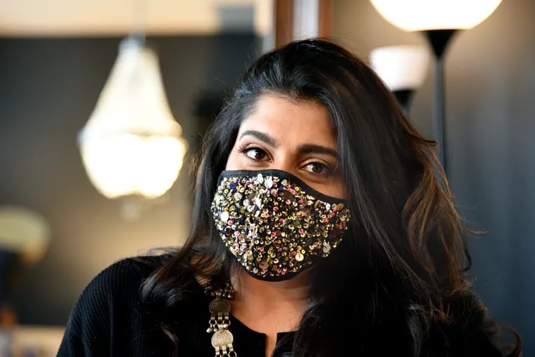 Gayatri Chopra of Simitri handbags and accessories wears one of the face masks she designed to supplement her business, after handbag sales took a hit during COVID-19.
