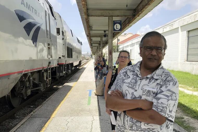 Jishnu Mukdrji (front) and Penny Jacobs wait to board an Amtrak train in Orlando, Fla., to travel to the memorial service for a fellow enthusiast who died on a group trip in July.