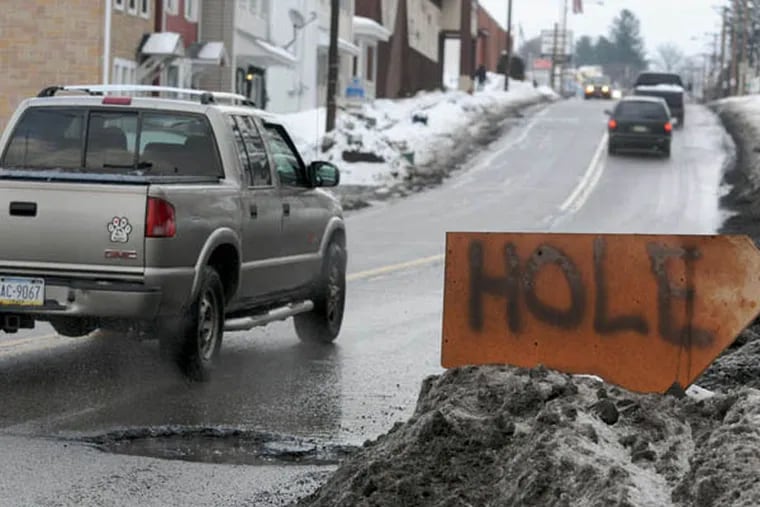 FILE - In this Tuesday, Feb. 18, 2014 file photo, a homemade sign warns motorists of a large pothole along West Market Street near North 23rd Street, in Pottsville, Pa. TRIP, a nonprofit organization that researches surface transportation issues, released a report last year estimating that "unacceptably rough" roads cost the average urban driver $377 a year in repairs - or a total of $80 billion nationwide. (AP Photo/Republican-Herald, David McKeown)