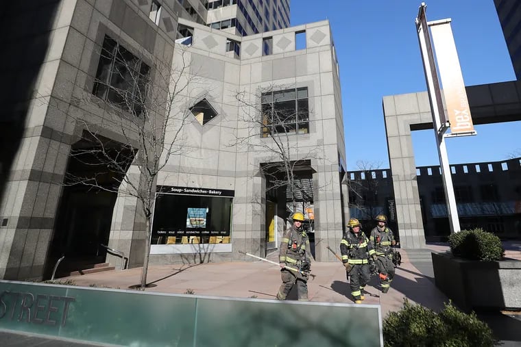 Philadelphia firefighters leave Commerce Square on the 2000 block of Market Street in Philadelphia on Sunday after a brief fire on the top floor.