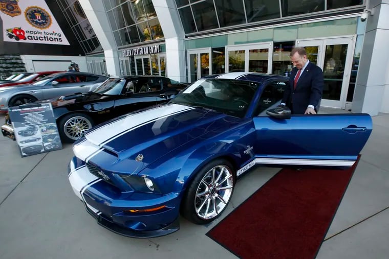 In this Oct. 23, 2019, file photo, McGregor Scott, the U.S. Attorney for the Eastern District of California, looks over a 2007 Ford Shelby GT500 displayed in Sacramento, Calif., that was among the vehicles seized by the federal government to be auctioned off. The cars belonged to owners of a San Francisco Bay Area solar energy company that have pleaded guilty for participating in what federal prosecutors called a massive Ponzi scheme that defrauded investors of $1 billion. Jeff and Paulette Carpoff entered pleas Friday, Jan. 24, 2020, involving the scam that could result in up to 30 years in prison for him, and up to 15 years in prison for her. (AP Photo/Rich Pedroncelli, File)