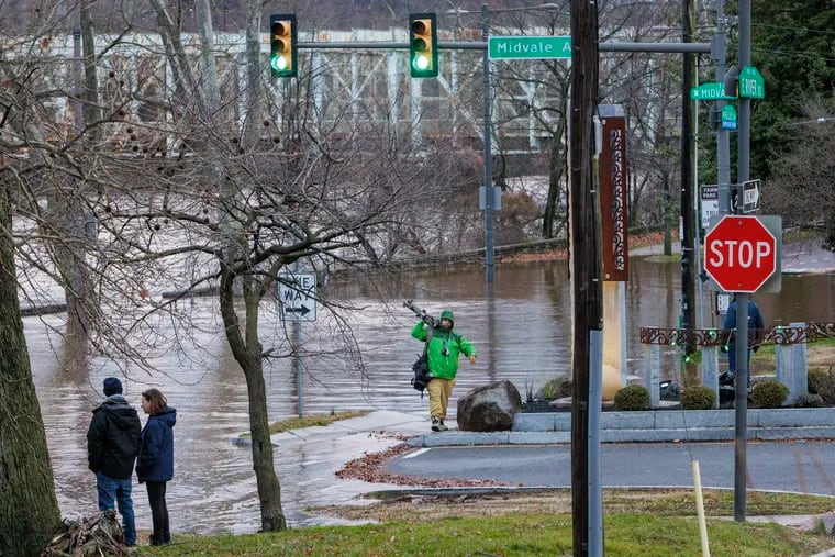Residents and media along Kelly Drive Wednesday at the bank of the Schuylkill River that flooded at Midvale Avenue.