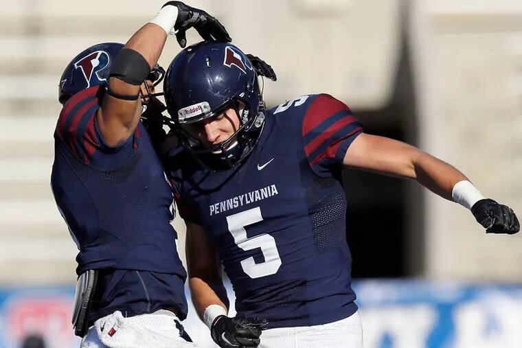Penn's Justin Watson (right) celebrates a first-quarter touchdown catch with teammate Cam Countryman against Cornell.