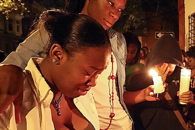 Friends and family gather for a vigil to remember Akhir "Geedy" Frazier. (Steven M. Falk/Staff Photographer)