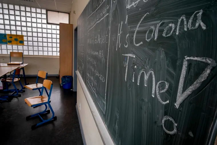 FILE -- In this Friday, March 13, 2020 photo a slogan on a chalkboard reads 'It's Corona Time' in an empty class room of a high school in Frankfurt, Germany, March 13, 2020. Germany plans to let smaller shops reopen next week after a weeks-long coronavirus shutdown and to start reopening schools in early May, but Europe’s biggest economy is keeping strict social distancing rules in place for now. (AP Photo/Michael Probst, file)